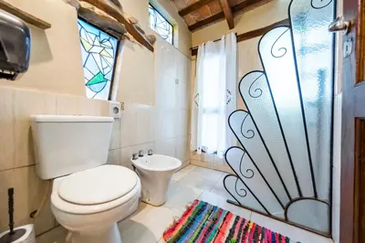 a bathroom with a toilet and a window and a rug at Posada El Pucara in San Javier