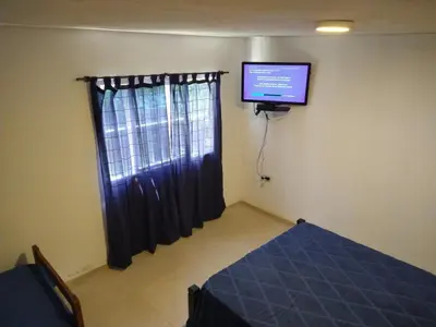 a room with a bed and a tv on the wall at El diquecito duplex in Casa Bamba