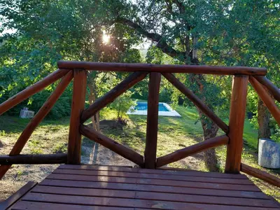 a wooden bridge with the sun shining through the trees at El diquecito duplex in Casa Bamba