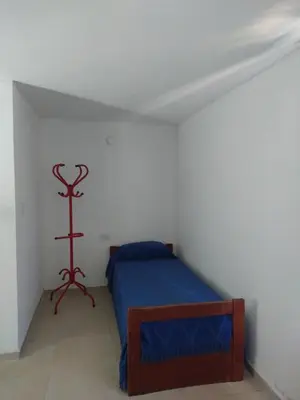 a bedroom with a blue bed in a white room at El diquecito duplex in Casa Bamba