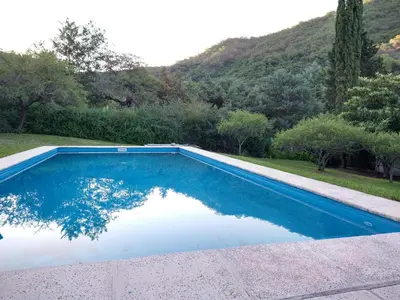 a blue swimming pool with a mountain in the background at El diquecito duplex in Casa Bamba