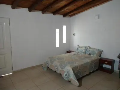 a bedroom with a bed in a white wall at El diquecito monoambiente in Casa Bamba