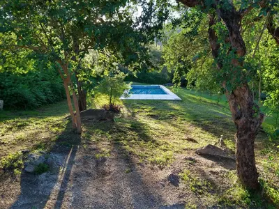 a swimming pool in the middle of a yard with trees at El diquecito monoambiente in Casa Bamba