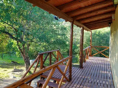 a wooden porch of a cabin with a wooden bridge at El diquecito monoambiente in Casa Bamba