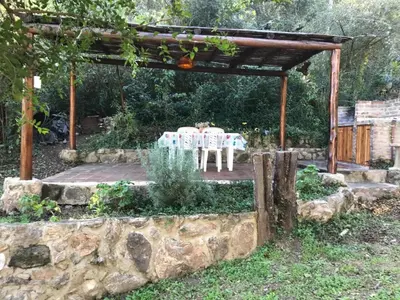 a patio with a table and chairs under a pergola at Inti Huasi in La Paisanita