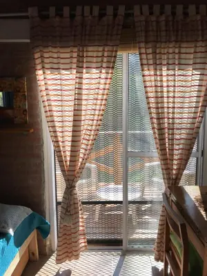 a window with curtains in front of a door at Inti Huasi in La Paisanita