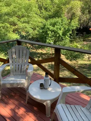 two chairs and a coffee table on a deck at Inti Huasi in La Paisanita