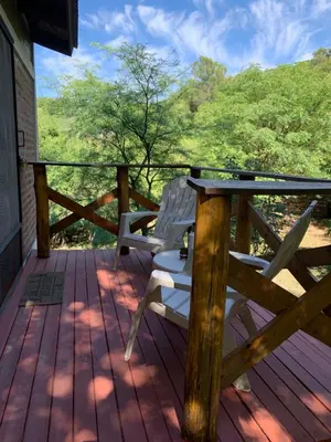 a wooden deck with a table and chairs on it at Inti Huasi in La Paisanita