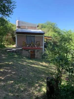 a house with a picnic table in front of it at Inti Huasi in La Paisanita
