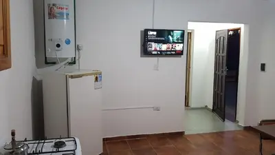 a kitchen with a refrigerator and a tv on the wall at Casa Kassel in Villa Cura Brochero