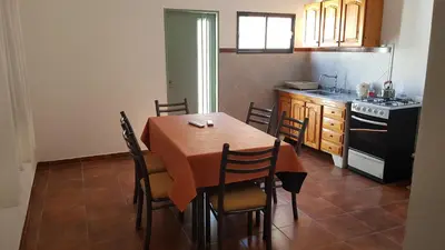a kitchen with a table with chairs and a stove at Casa Kassel in Villa Cura Brochero