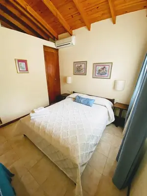 a bedroom with a white bed in a room at Lo de la Omi in Villa General Belgrano