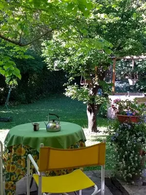 a table with a tea kettle on it in a garden at Lo de la Omi in Villa General Belgrano