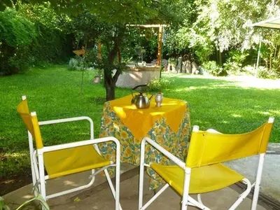 a yellow table with two chairs and a tea kettle on it at Lo de la Omi in Villa General Belgrano