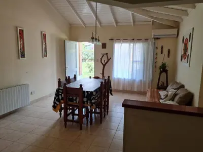 a kitchen and dining room with a table and chairs at Casa Anémona in Merlo
