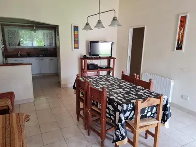 a kitchen and dining room with a table and chairs at Casa Anémona in Merlo