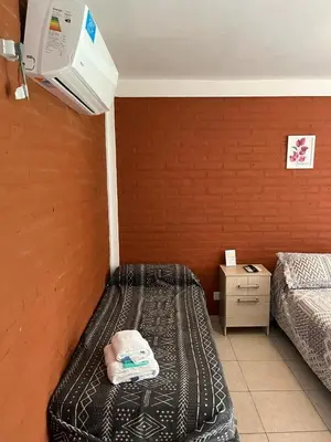 a room with two beds and a wall at Hotel Aimara in Mina Clavero