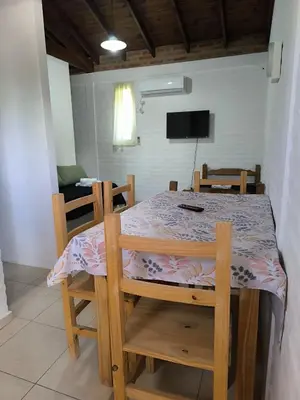 a table and chairs with a table and a tv at Hotel Aimara in Mina Clavero