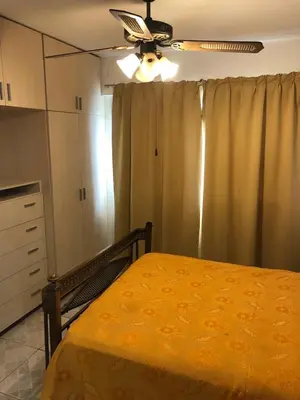 a bedroom with a yellow bed and a ceiling fan at Casa Miradores del Lago in Bialet Massé