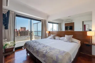 a bedroom with a large bed with a large window at AT Suites in Cordoba