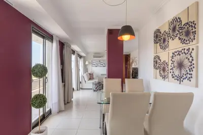 a dining room with white chairs and purple walls at AT Suites in Cordoba