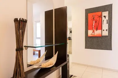 a glass display case in a living room with a painting at AT Suites in Cordoba