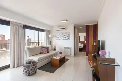a living room with a couch and a large window at AT Suites in Cordoba