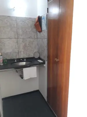 a bathroom with a sink and a wooden door at Departamento del centro in Cordoba