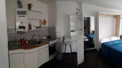 a small kitchen with a sink and a bed in a room at Departamento del centro in Cordoba
