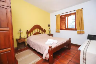 a bedroom with a bed and a window at Cabaña Modestita - FINCA PUDUAM in Villa General Belgrano