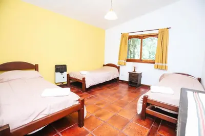 a room with two beds and a window at Cabaña Modestita - FINCA PUDUAM in Villa General Belgrano