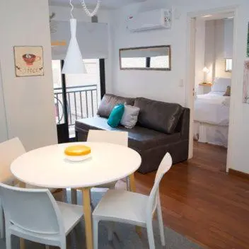 a living room with a couch and a table and chairs at Guemes Apart Nueva Cordoba in Cordoba