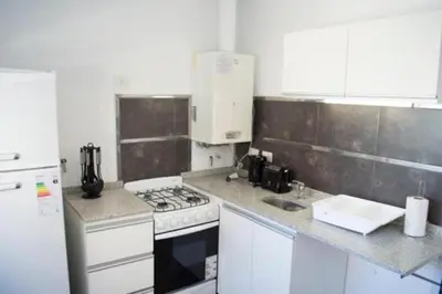 a kitchen with a stove and a white refrigerator at Guemes Apart Nueva Cordoba in Cordoba