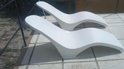 a pair of white chairs sitting on a sidewalk at Casa de Alquiler 1 in Tanti