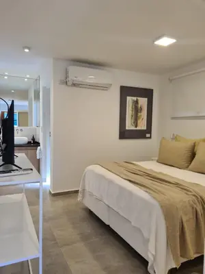 a bedroom with a bed and a desk with a computer at Be mas apartamentos boutique Villa Gral Belgrano in Villa General Belgrano