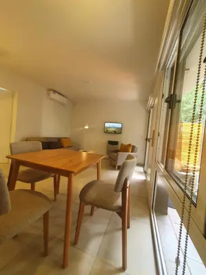 a dining room with a wooden table and chairs at Be mas apartamentos boutique Villa Gral Belgrano in Villa General Belgrano