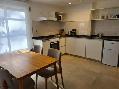 a kitchen with a wooden table and a table and chairs at Be mas apartamentos boutique Villa Gral Belgrano in Villa General Belgrano