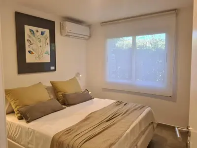 a bedroom with a large bed with a window at Be mas apartamentos boutique Villa Gral Belgrano in Villa General Belgrano