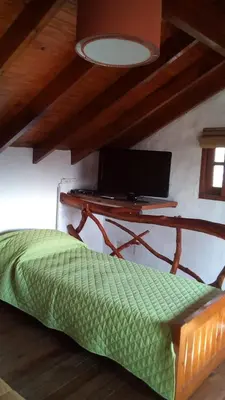 a bedroom with a desk and a bed in a room at Los Arbolitos Cabañas y Aparts in Santa Rosa de Calamuchita