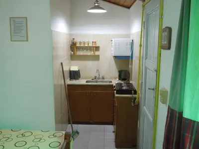 a small kitchen with a sink and a stove at Cabañas La Pirca in Santa Rosa de Calamuchita