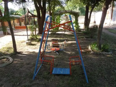 a swing set in a yard with a playground at Cabañas La Pirca in Santa Rosa de Calamuchita