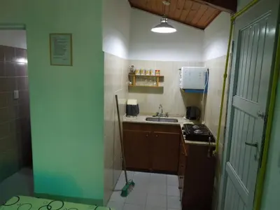 a small kitchen with a sink and a stove at Cabañas La Pirca in Santa Rosa de Calamuchita
