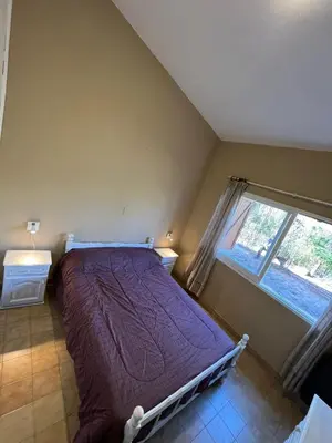 a bed in a bedroom with a window at La Luisa in Merlo