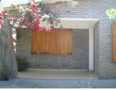 a brick building with a door with flowers on it at La Luisa in Merlo