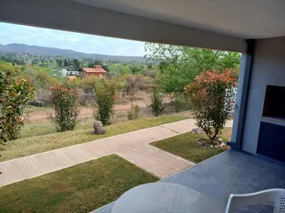 a view of a garden from a balcony of a house at Luces Casas de Montaña in Villa del Dique