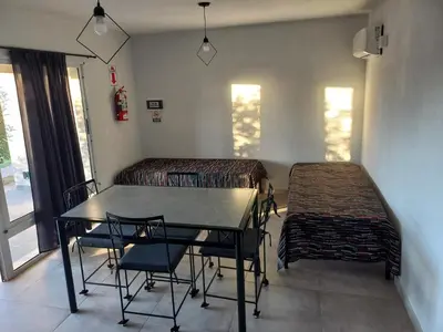 a dining room with a table and chairs and windows at Luces Casas de Montaña in Villa del Dique