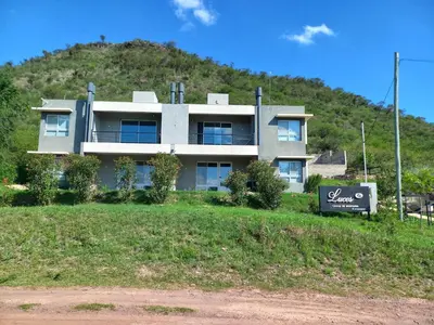 a building on a hill with a sign in front of it at Luces Casas de Montaña in Villa del Dique
