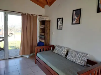 a bedroom with a bed and a sliding glass door at Loma Alta Apart in Villa Yacanto