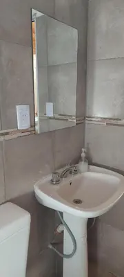 a bathroom with a sink and a mirror and a toilet at Loma Alta Apart in Villa Yacanto