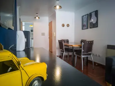 a dining room with a table and chairs and a yellow car at Laprida y Trejo Apartamento in Cordoba